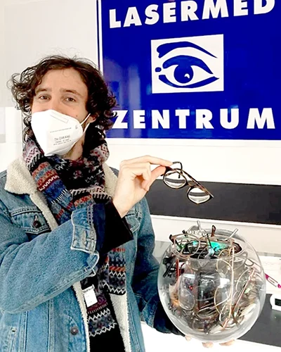 Augenlasern-Alexander Augenlaserbehandlung: Junger Mann wirft nach der Femto-Lasik Augenlaserbehandlung seine Brille in ein Glas für Brillenspenden