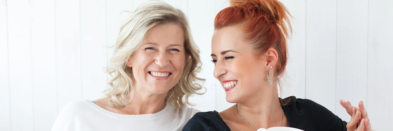 Zwei Frauen unterschiedlichen Alters lachen gemeinsam – passend zur Altersgrenze beim Augenlasern bei Astigmatismus