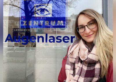 Junge Frau mit Brille steht vor ihrem Voruntersuchungstermin vor dem Augenlaser-Zentrum in der Schönhauser Allee