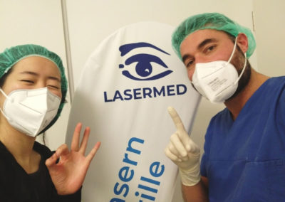 Femto-Lasik Erfahrung. Junge Frau lächelt nach der Femto-Lasik Augenlaserbehandlung zusammen mit Augenchirurg Dr. med. Rihawi