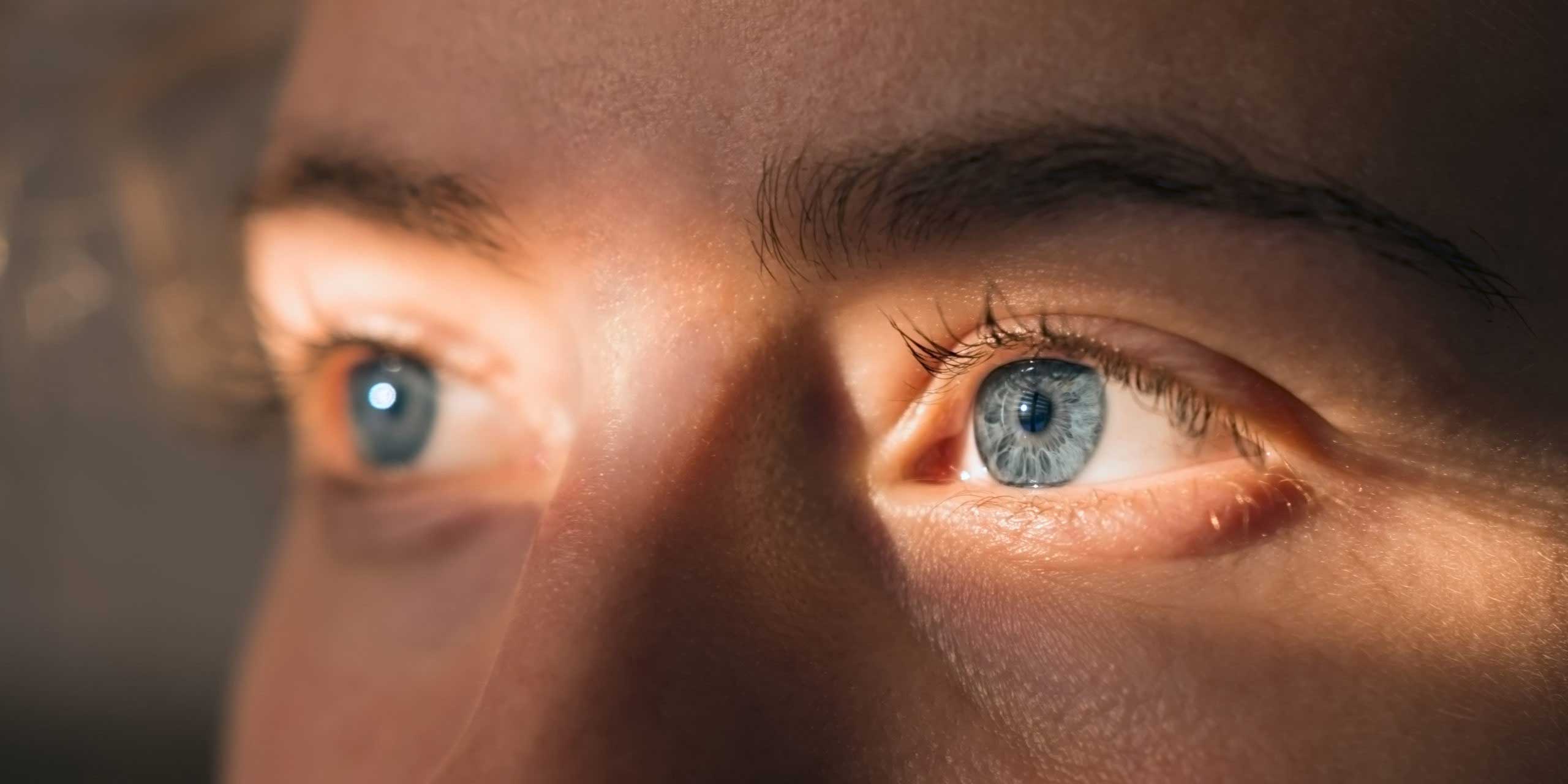 EDOF Linse: Nahaufnahme vom Gesicht einer Frau mit einem Sonnenstrahl über den blauen Augen