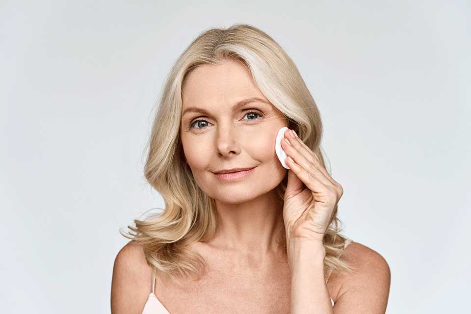 Linsentausch (CLE) Behandlung: Frau mittleren Alters reinigt sich das Gesicht vor ihrer Linsentausch Behandlung bei Lasermed
