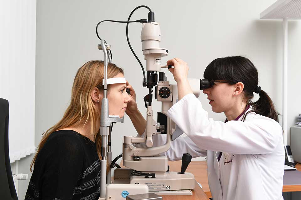 Augenärztin führt eine Augenuntersuchung bei einer jungen Frau durch in der Augenlaser-Klinik am Wittenbergplatz von Lasermed